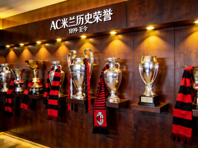 AC米兰历史荣誉墙，多座冠军奖杯与红黑围巾展示